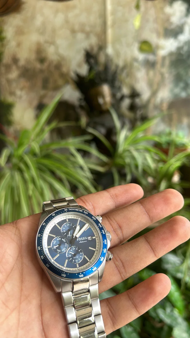 A Fossil watch resting in a hand
